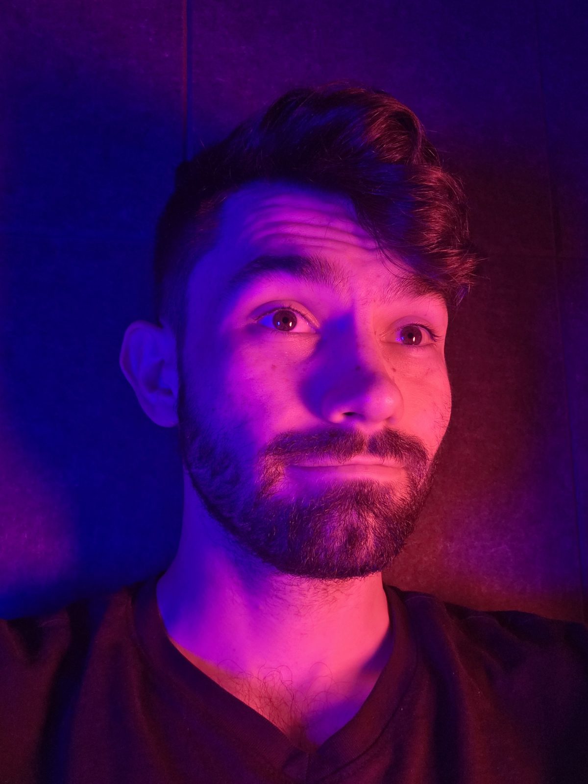 AJ Finnegan, the illustrator, animator and designer behind Finnegan Studio, in a portrait lit in violet and blue