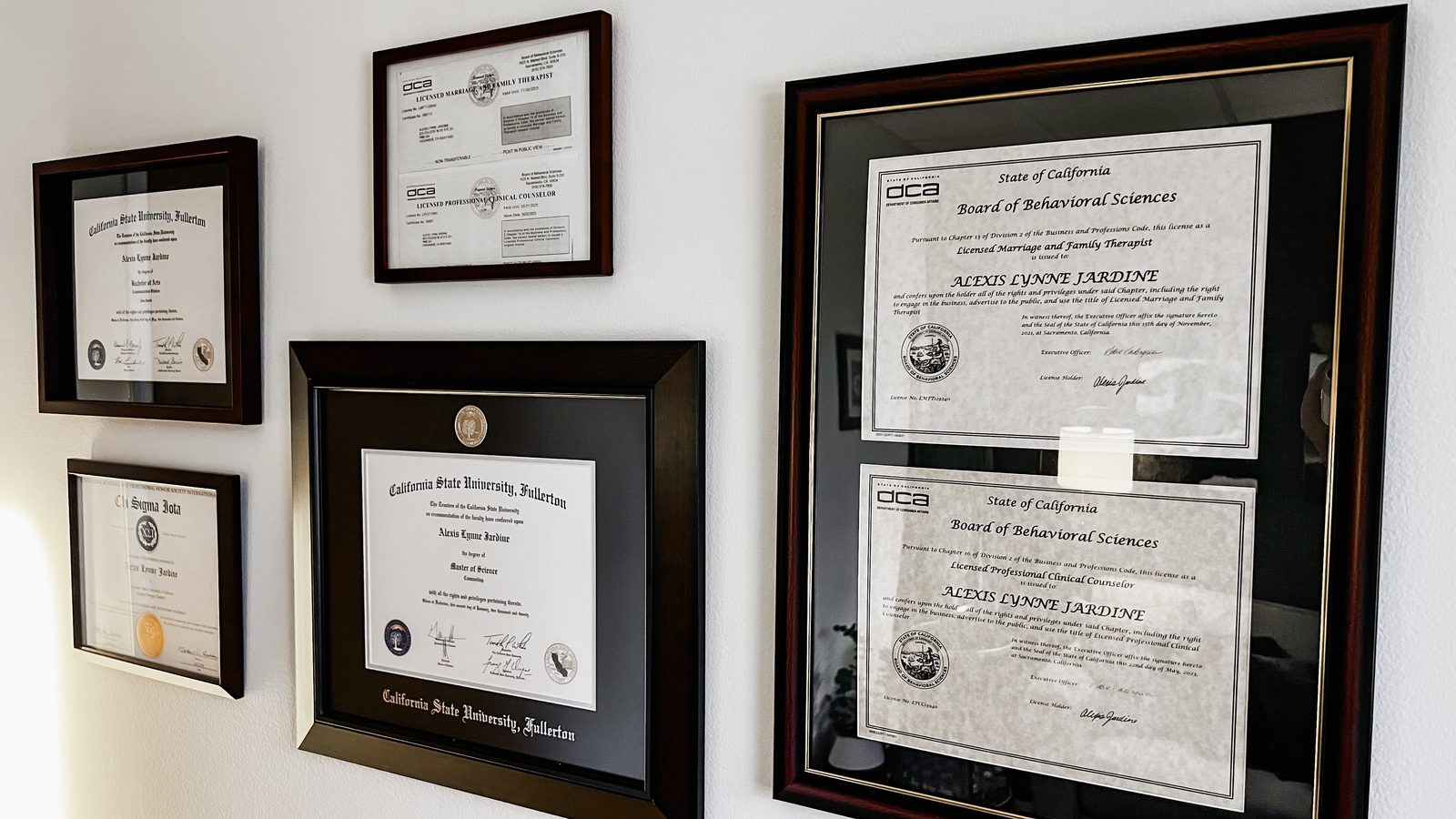 Framed California licenses for a marriage and family therapist and a professional clinical counselor beside California State University, Fullerton degrees, all in the name Alexis Lynne Jardine