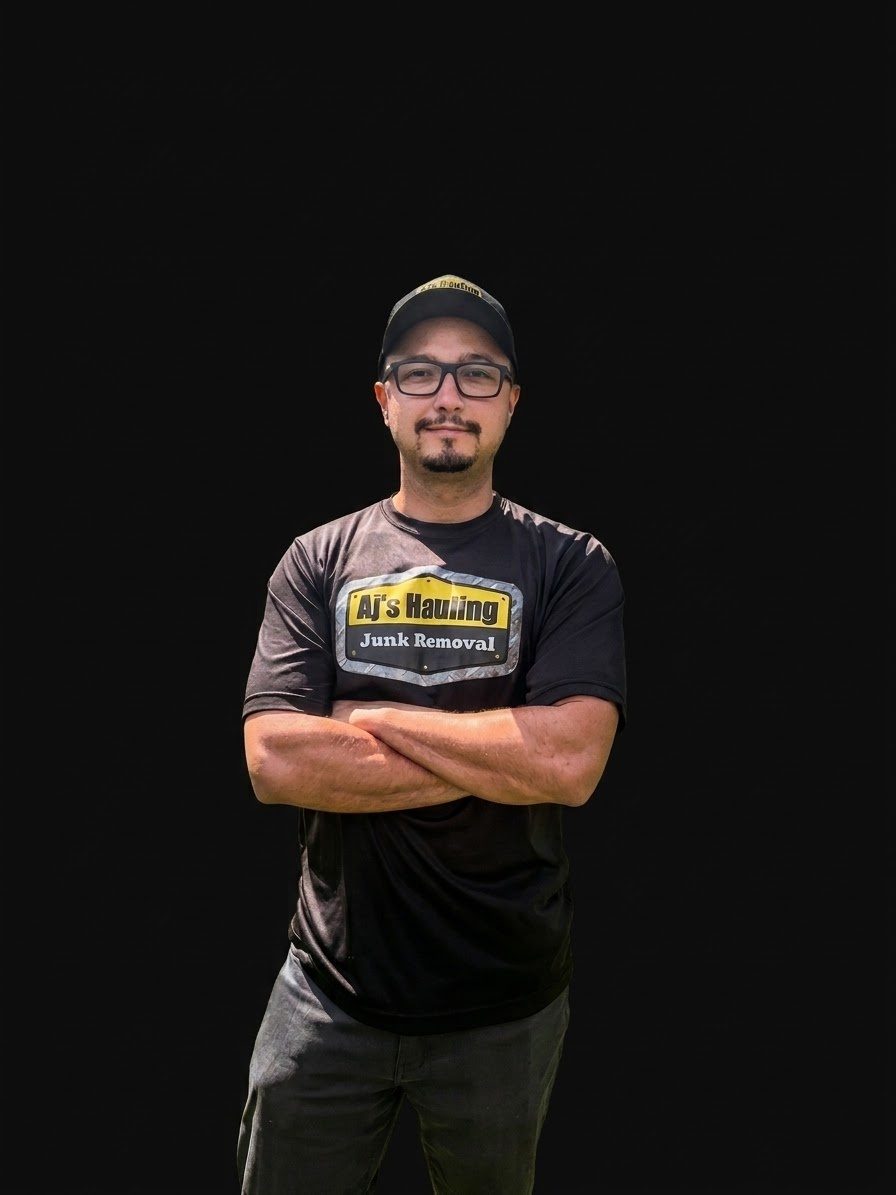 Andrew DePalma, founder of AJ's Hauling LLC, in a black AJ's Hauling T-shirt and cap with arms crossed