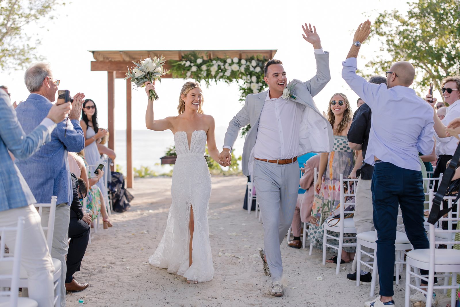 A bride and groom celebrating as they walk back down the aisle at a beach wedding in Punta Cana