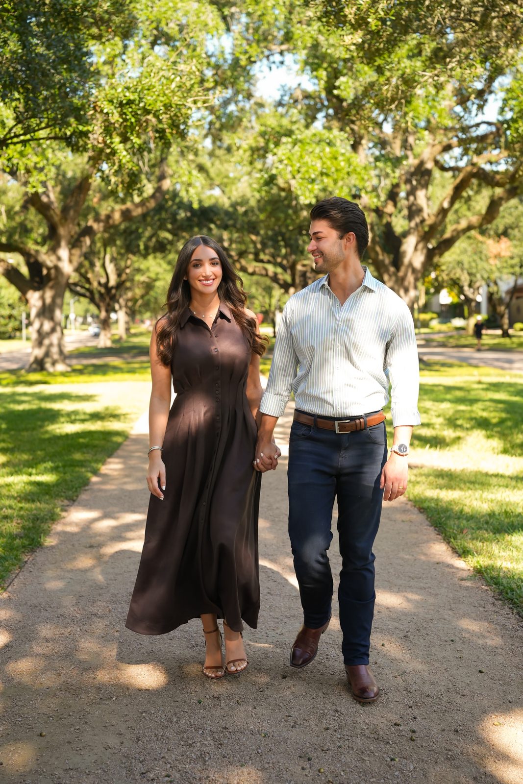 Ariana Stanley walking hand in hand with her husband Ethan along a tree-lined path