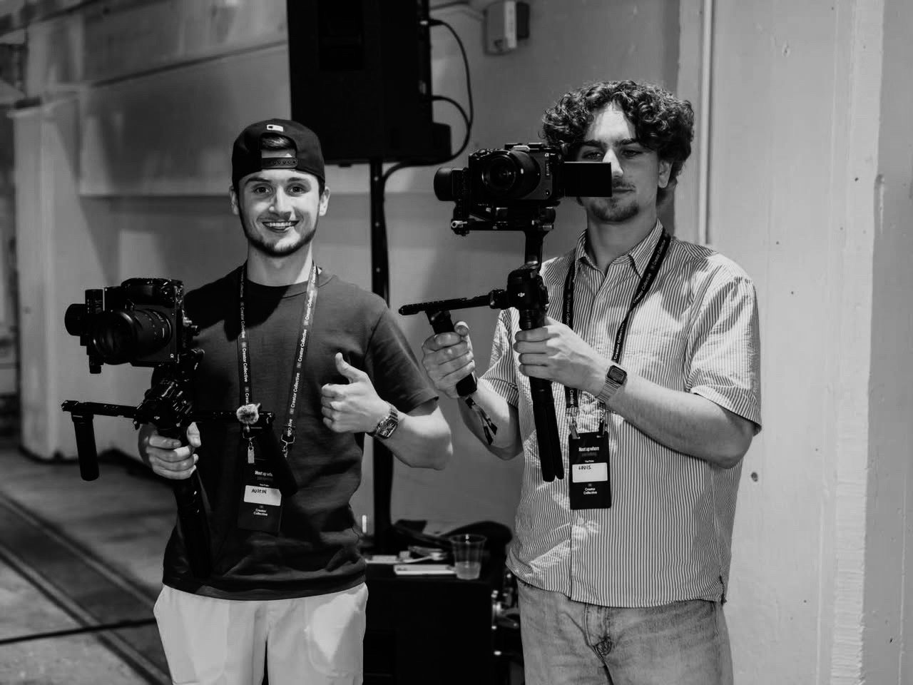 Austin Coburn, left, giving a thumbs-up while holding a gimbal-mounted camera next to a Klicc teammate filming at a Creator Collective event