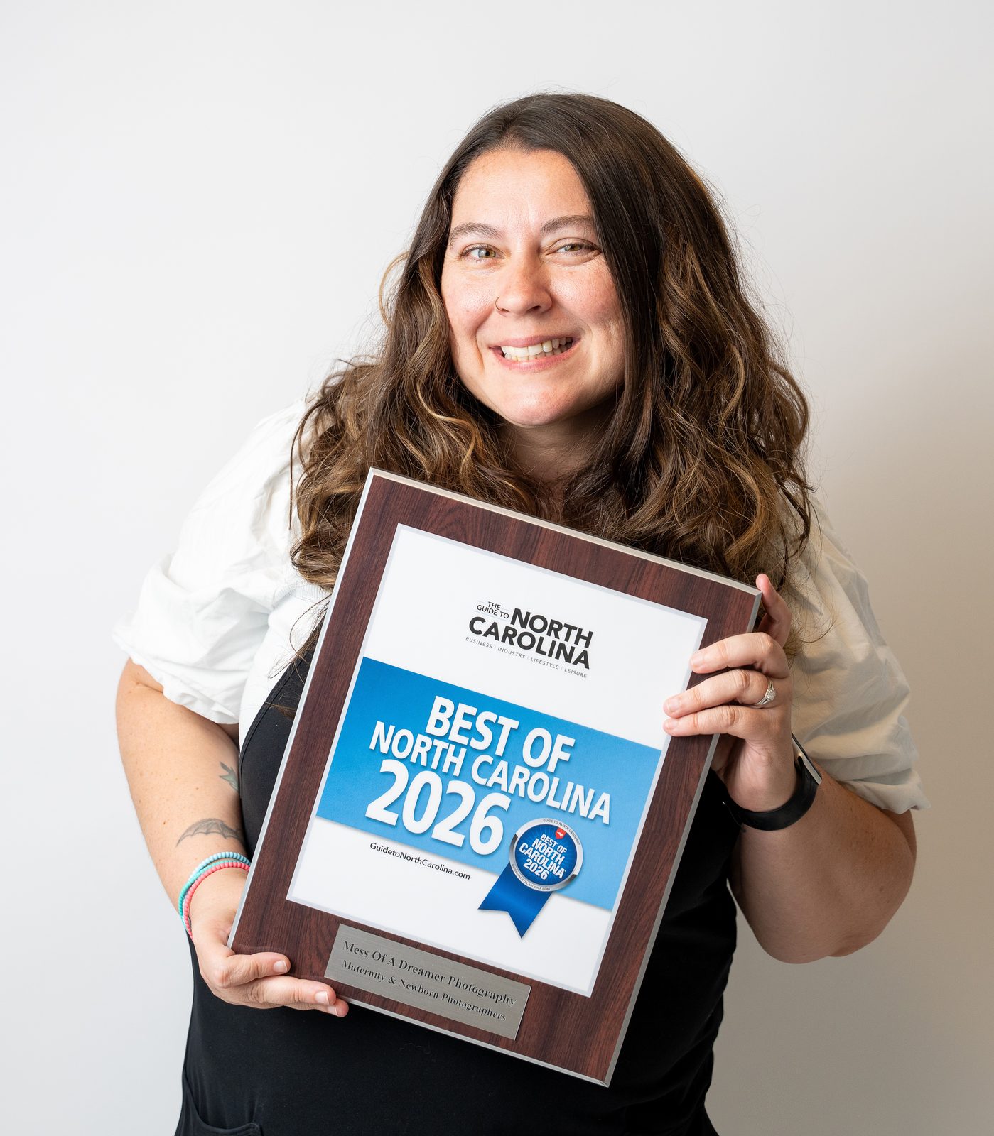 Bernice Isley, founder of Mess Of A Dreamer Photography, smiling as she holds her Best of North Carolina 2026 award plaque