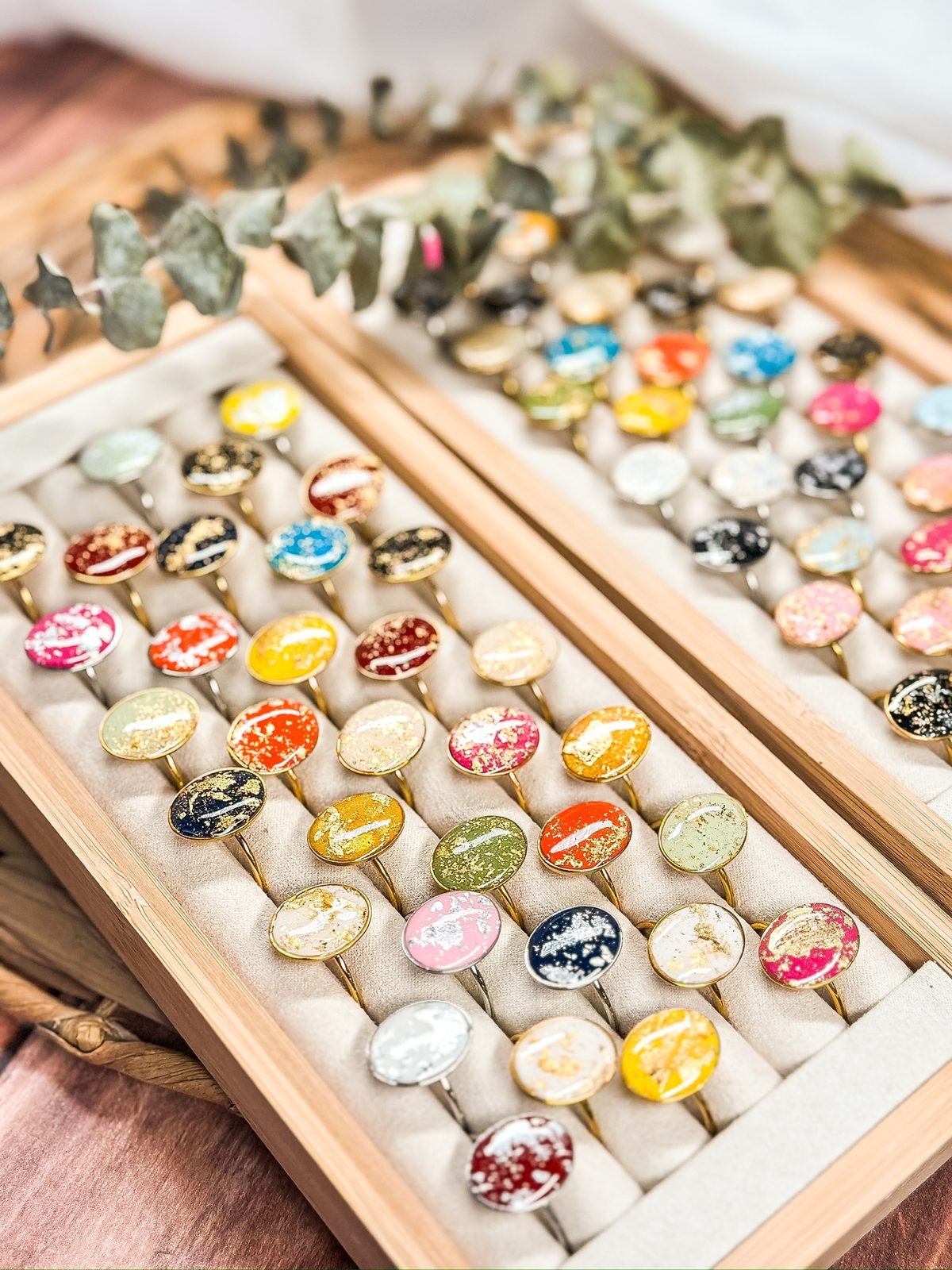 A wooden tray of patterned stud earrings and rings from The Dappled Wood