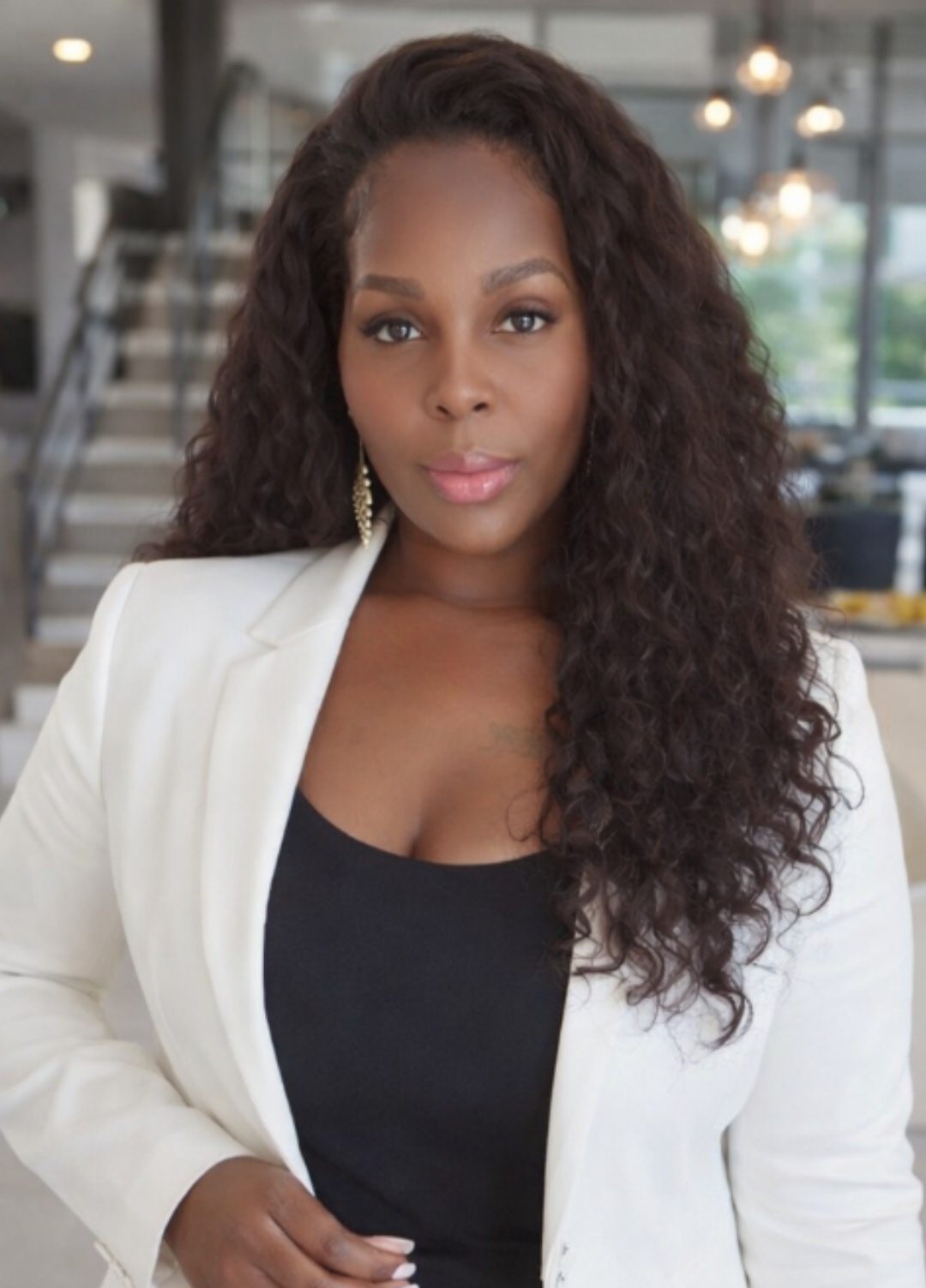 Carlene Herring in a white blazer and black top in a bright, modern interior