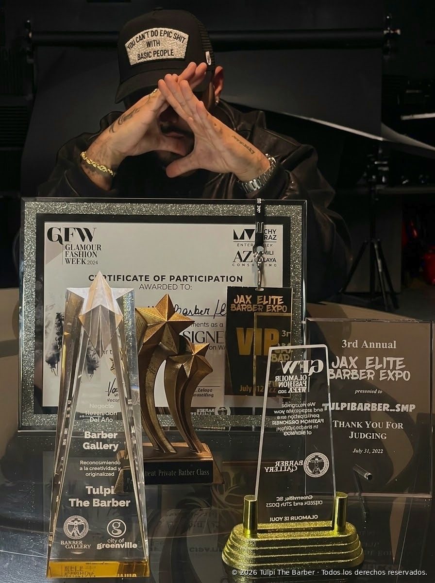 Carlos Turpeau Ramos with plaques and recognitions for barber education, community service and industry judging