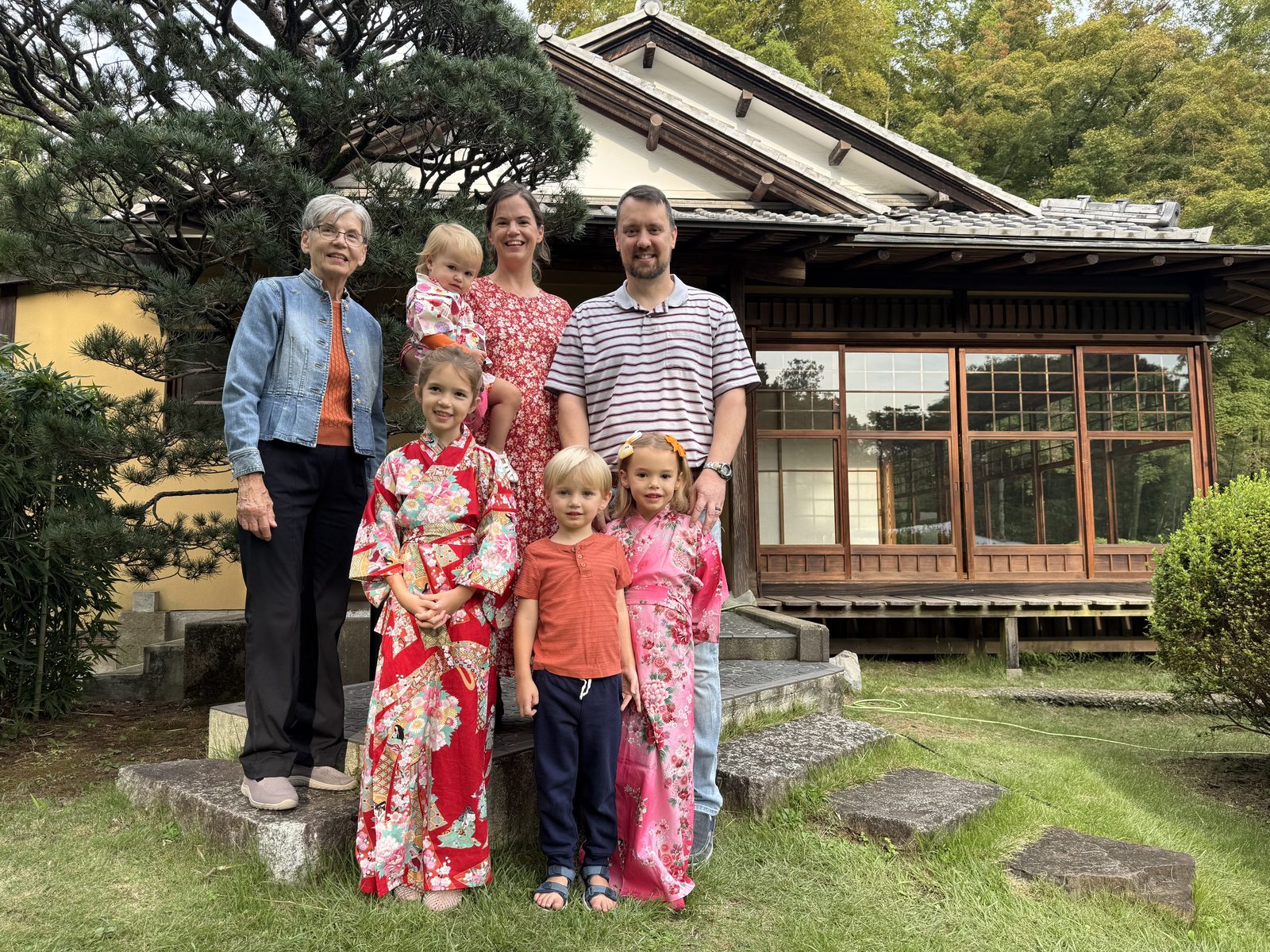 Casey Carmical with family, the children in kimonos, outside a traditional Japanese house with a garden