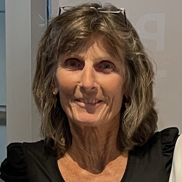 Celia Bertoia, founder of the Harry Bertoia Foundation, smiling with her glasses pushed up on her head