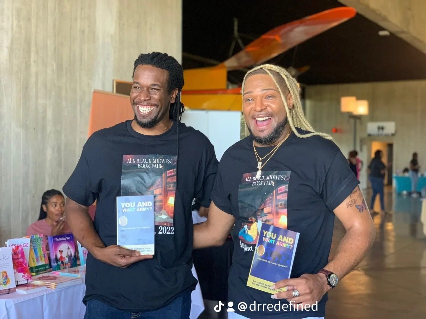 Dr. Jesse Sanders and his co-author holding copies of You and What Army? at the All Black Midwest Book Fair