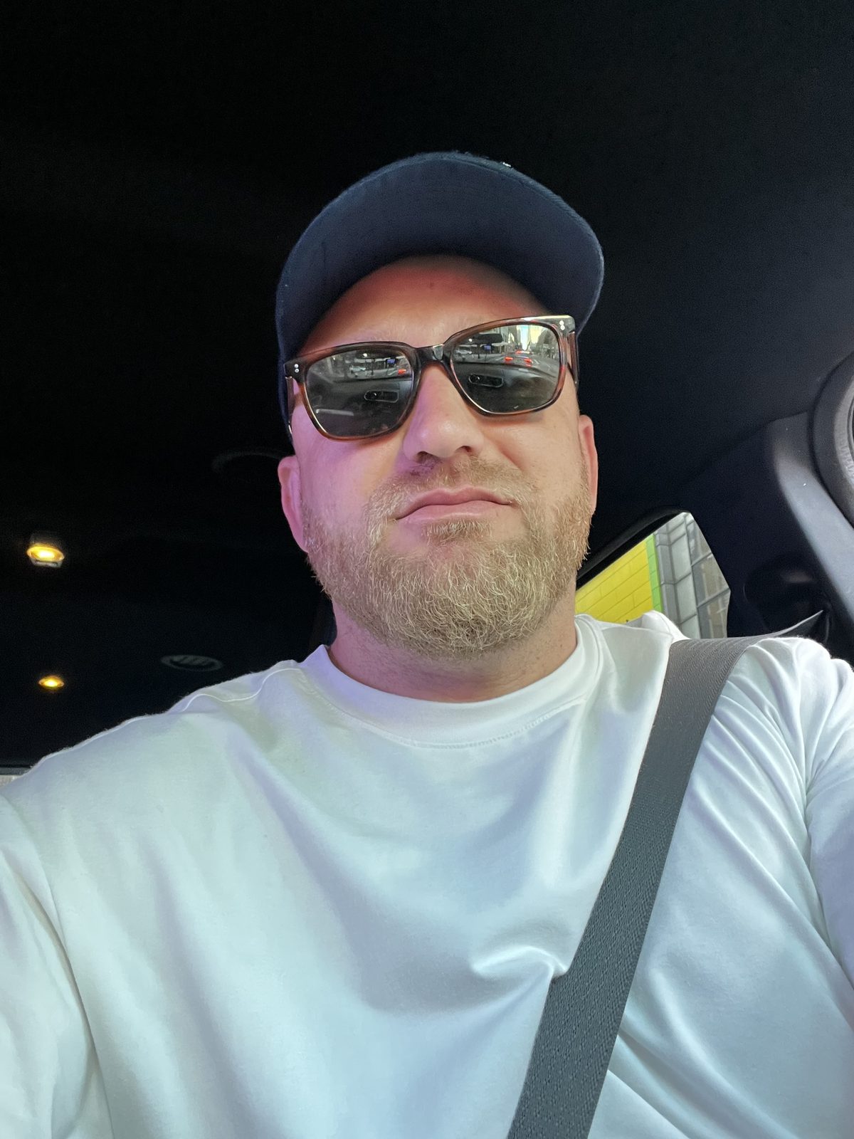 Elson Beluli, founder of Mega Group, in a navy cap and sunglasses