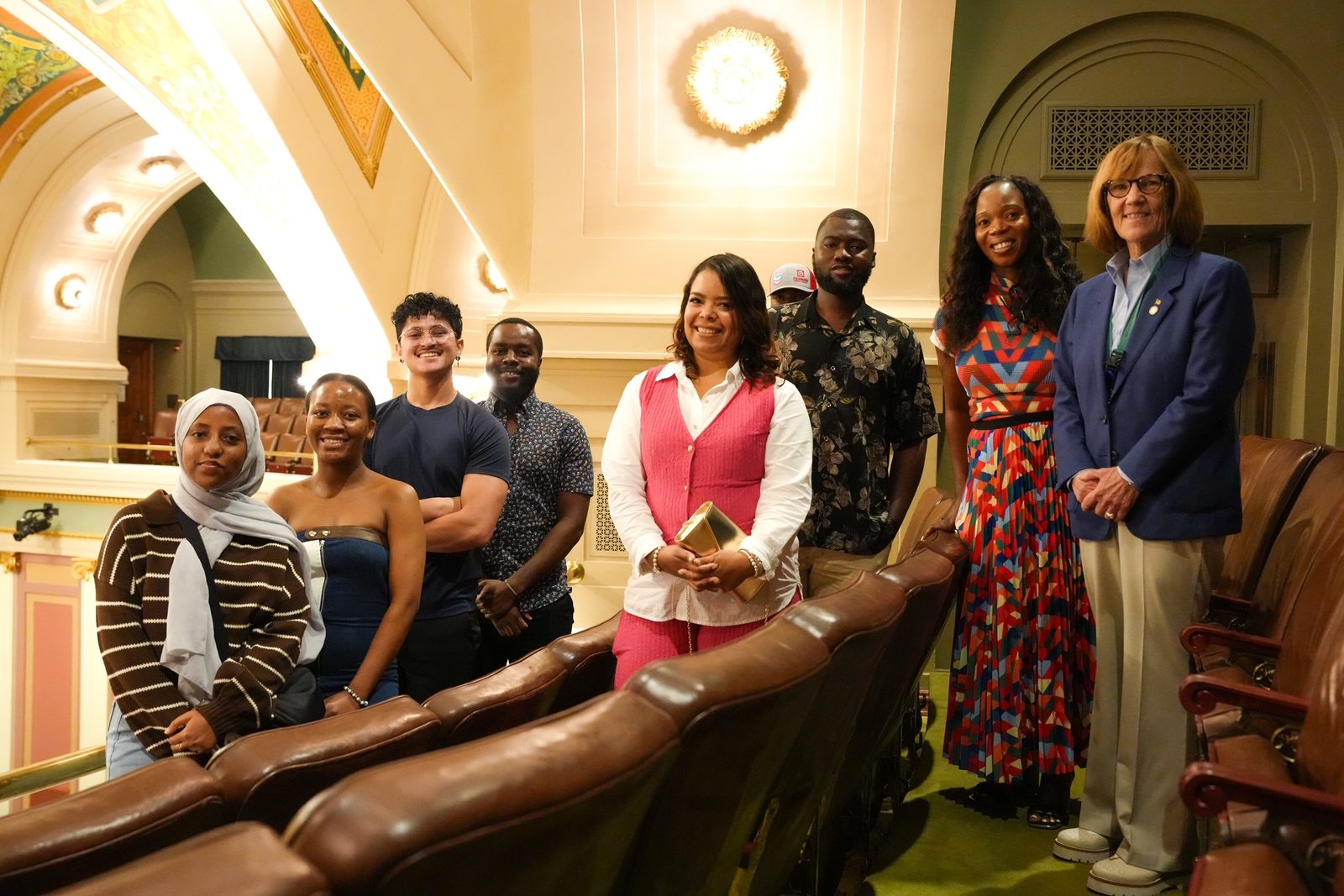 Jugaad Leadership Program participants standing between rows of leather seats in an ornate historic chamber