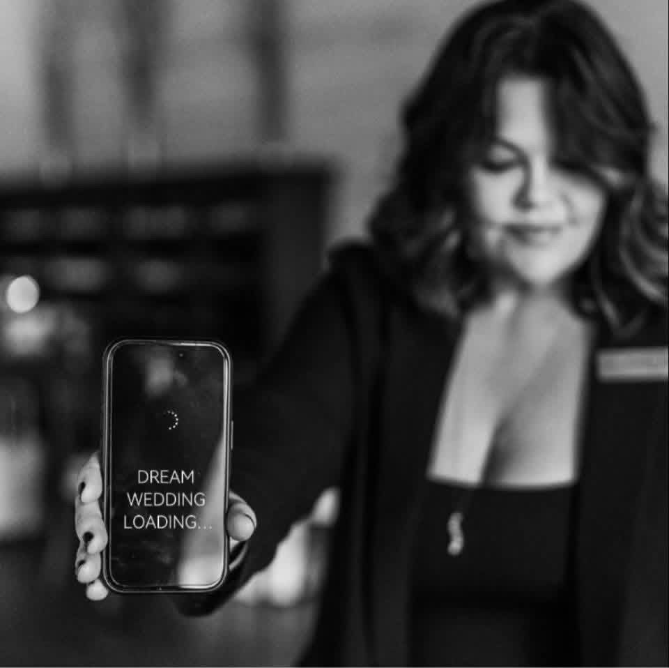 Jennifer Wilson holding up a phone that reads Dream wedding loading