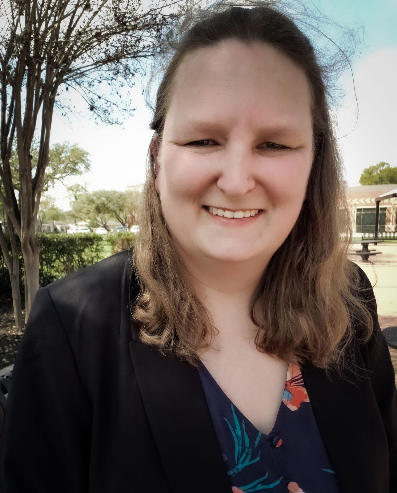 Katie Tschida, founder of KRT Virtual Assistant, smiling outdoors in a black blazer and floral top in Houston, Texas
