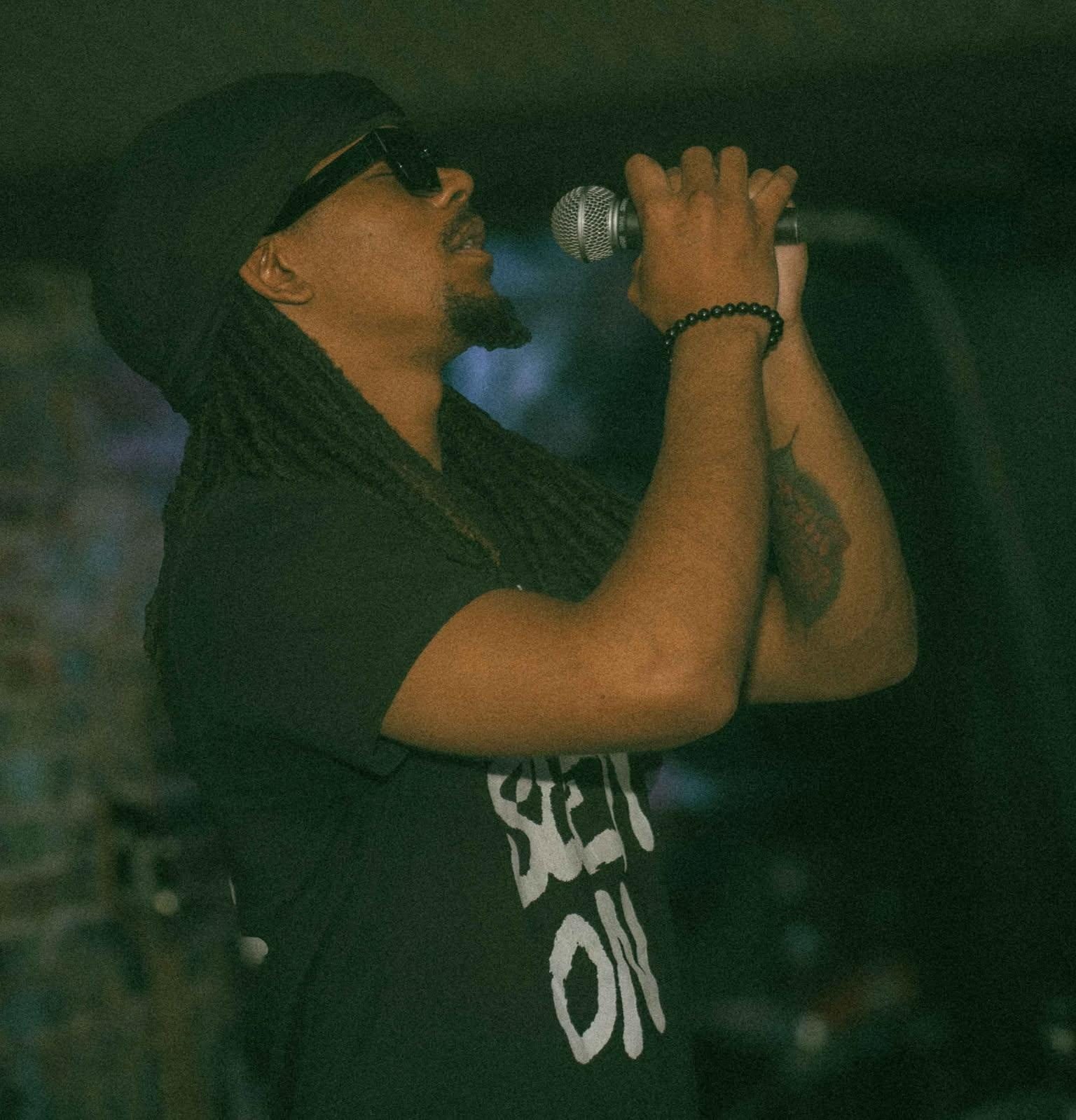 Khalid Thornton performing live on stage with a microphone