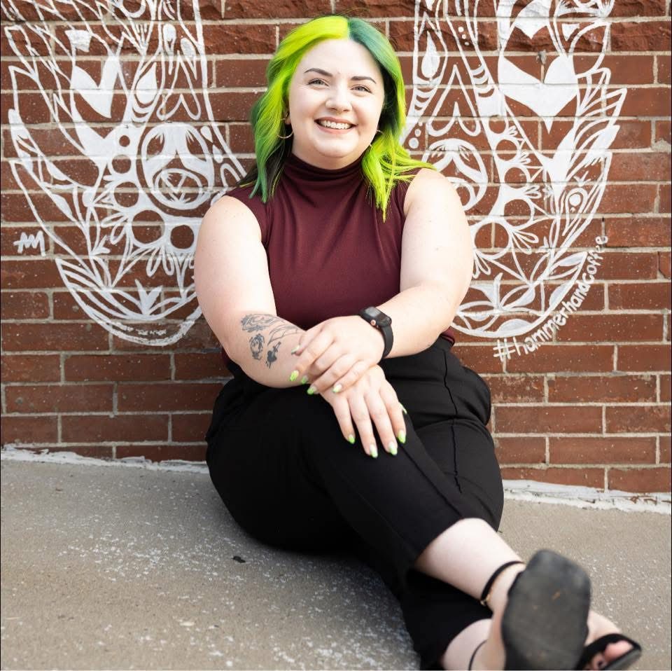 Lillian London, founder of London Cleaning Services in Kansas City, smiling in front of a painted brick mural