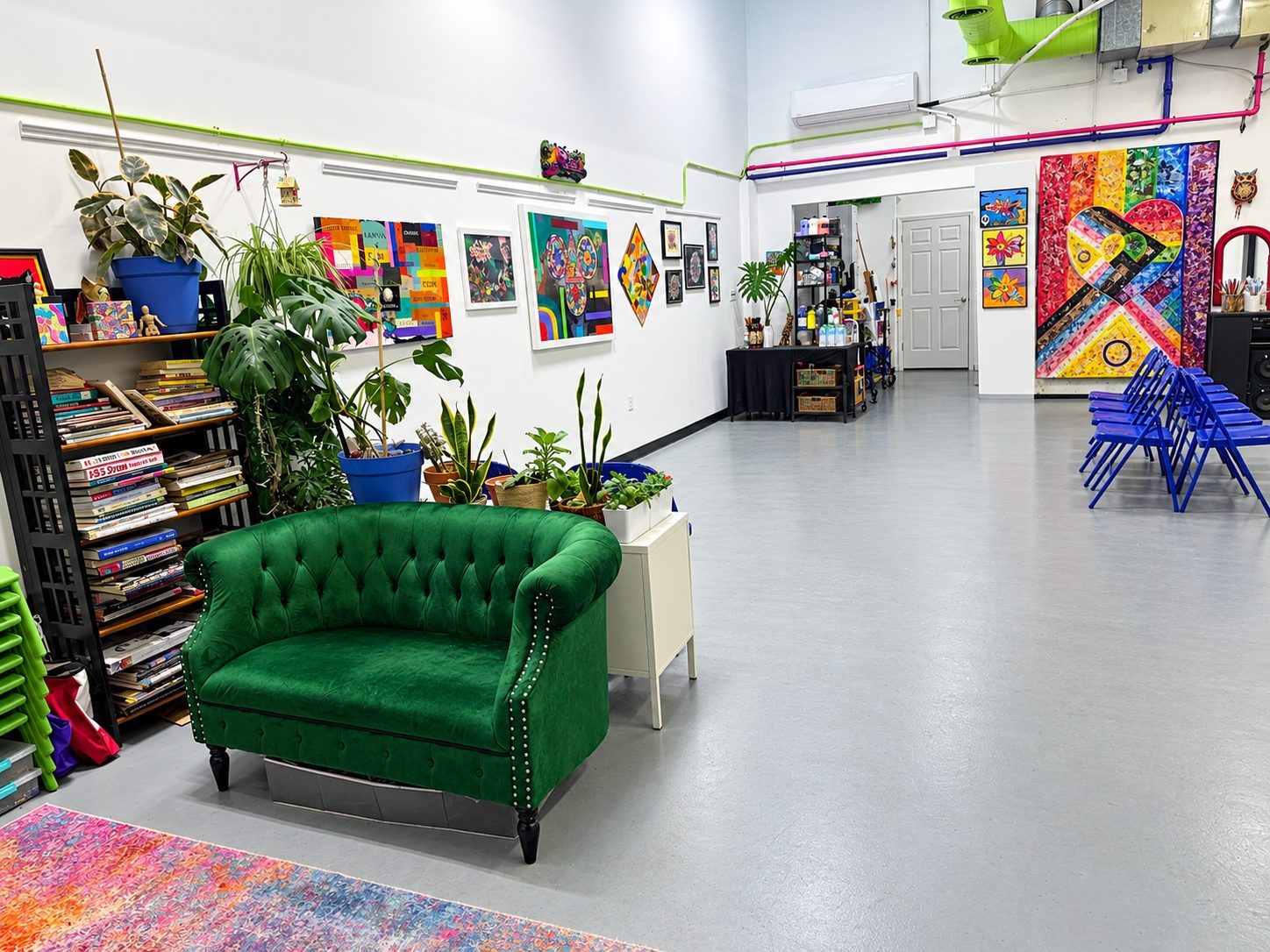 Inside the Keep Creating Art Wellness Center studio in Montclair: a green velvet sofa, shelves of art books, plants and colourful artwork on white walls