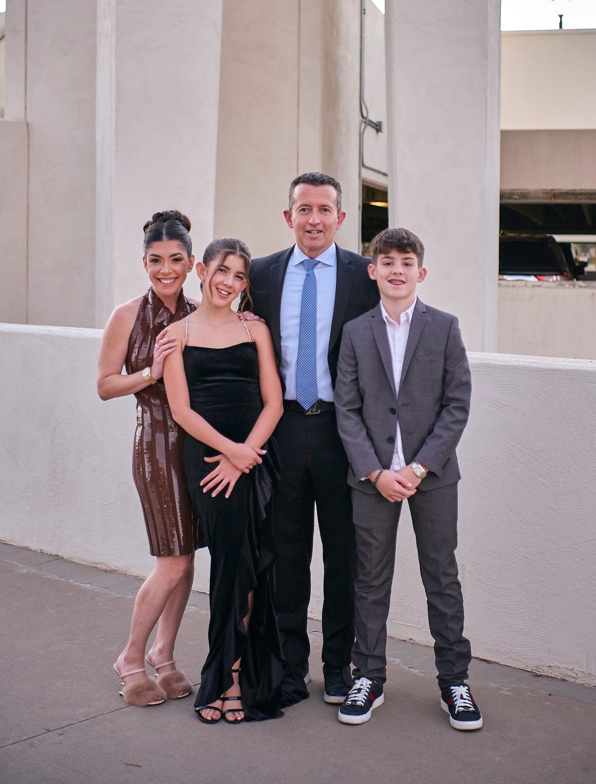 Oleg Bortman in a dark suit and blue tie with his family, dressed for an evening out