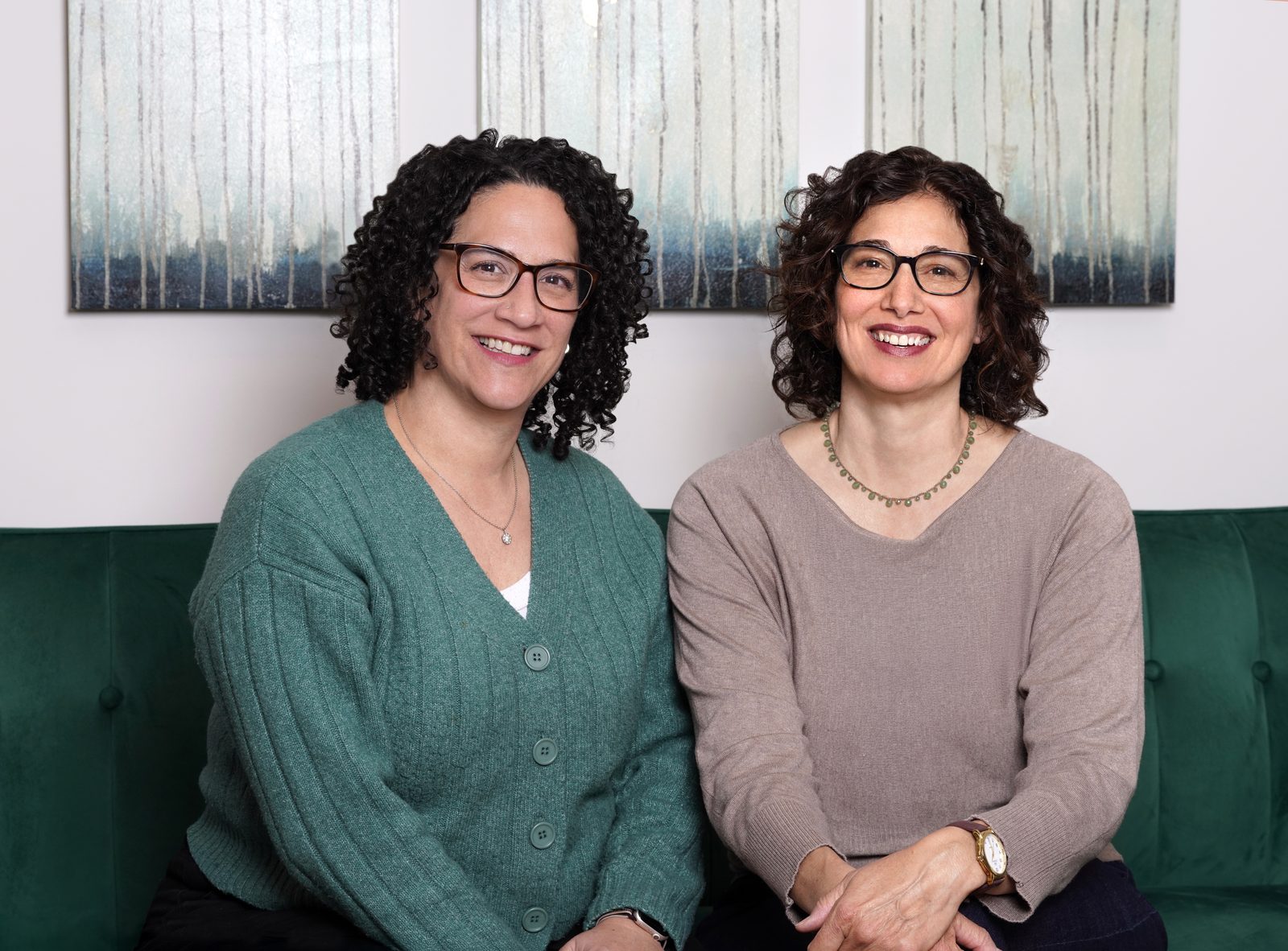 Stephanie Bourgeois and Tessa Vining, co-founders of the Mind Body Therapy Collective, seated together on a green velvet sofa in their Montclair, New Jersey space