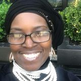 Athenae Evans, Administrator of Roxborough Home for Women, smiling in glasses, a black head wrap and layered pearl necklaces