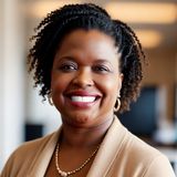 Dr. Orletta Caldwell, founder of Beyond Existing Enterprises, smiling in a camel cardigan and pearl necklace