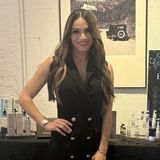 Kai Boyer, founder of Thera Glow Labs, in a black dress at a Thera Glow Labs event table