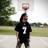 Khalid Thornton, the Cleveland artist and producer known as KTGODUMB!, standing on an outdoor basketball court in a number 7 jersey