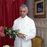 Lazarus Douvos, New York hairstylist and founder of Lazarus Douvos Hair & Fragrance, arranging roses in a white coat