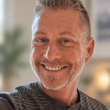 Paul McLellan, former owner of Service Lighting and LightBulbs.com, smiling in a grey henley
