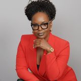 Priscilla Peete, founder and CEO of Peete Vending, in a red blazer and black glasses with her chin resting on her hand