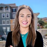 Rebecca Beebe, founder of Yellow Rose Counseling, smiling with arms crossed in a black blazer and teal top on a sunny balcony